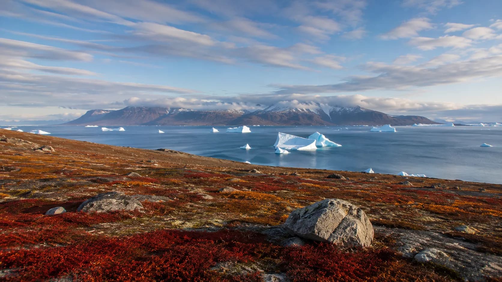 Nunavut's Arctic tundra with distant icebergs
